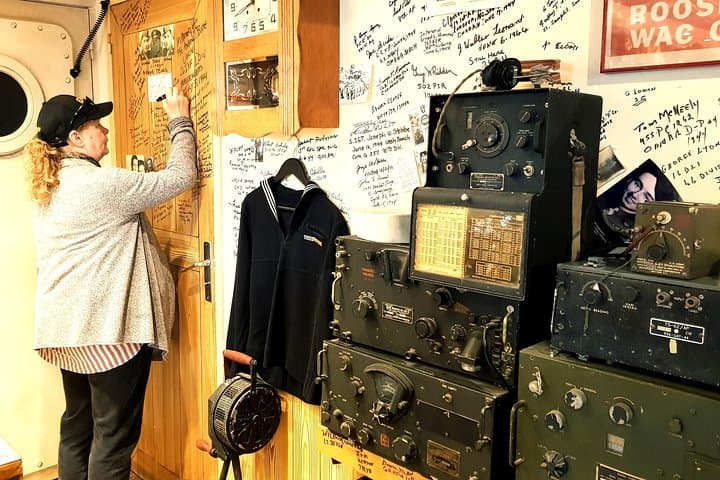 Signing the wall on behalf of her father at the famous Roosevelt Cafe (Utah Beach)