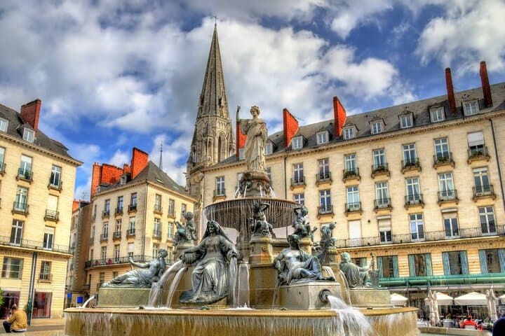 Royal Square: The monumental fountain symbol of the city, with the Basilica of St. Nicholas in the background.
