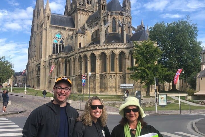 Christèle posing with couple on a private tour in front of Bayeux cathedral