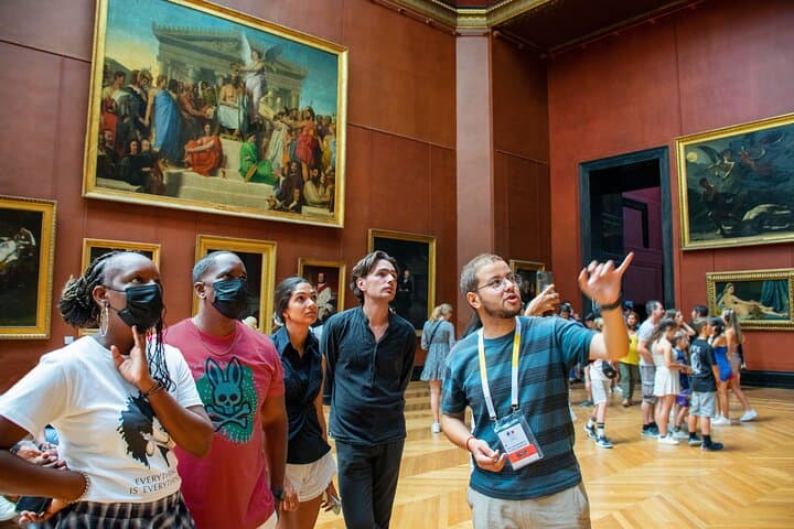 1 guide showing artworks to tourists at the Lovure