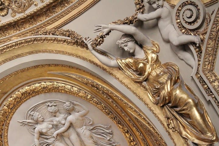Ornate gilded sculpture detail inside the Louvre Museum, Paris.